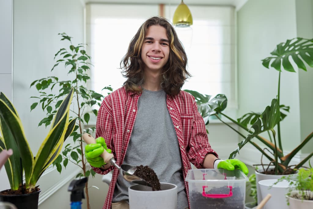 Guy teenager caring replanting indoor plants in po 2024 12 08 02 05 57 utc optimise